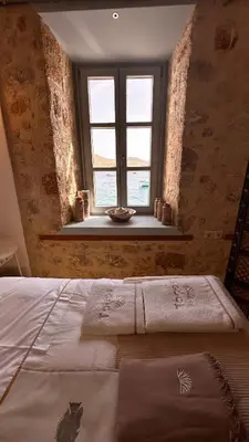 a bedroom with a bed and a window at H-aris Seafront Mansion in Halki