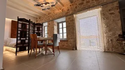 a dining room with a table and chairs and a window at H-aris Seafront Mansion in Halki