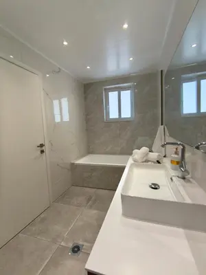 a white bathroom with a sink and a shower at Downtown Luxury Apartment in Rhodes Town