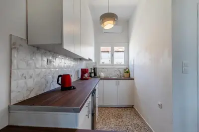a kitchen with white cabinets and a wooden counter top at Caserma Regina in Rhodes Town
