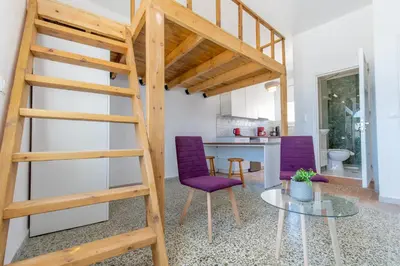 a loft bed with purple chairs in a living room at Caserma Regina in Rhodes Town