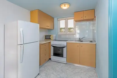 a kitchen with a white refrigerator and a sink at Haraki De Sol Beach Apartments in Haraki