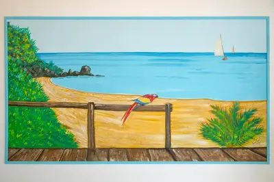 a painting of a fence with a boat in the water at Haraki De Sol Beach Apartments in Haraki