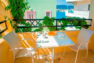 a table and chairs on a balcony with a view at Haraki De Sol Beach Apartments in Haraki