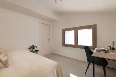 a bedroom with a bed and a desk and a window at Evilion Island Residence in Ixia