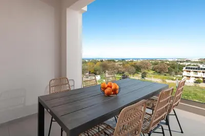 a bowl of oranges on a wooden table with chairs at Evilion Island Residence in Ixia