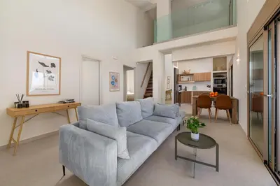 a living room with a blue couch and a table at Evilion Island Residence in Ixia