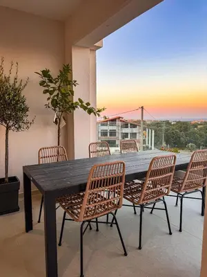 a dining table and chairs on a balcony with a view at Evilion Island Residence in Ixia