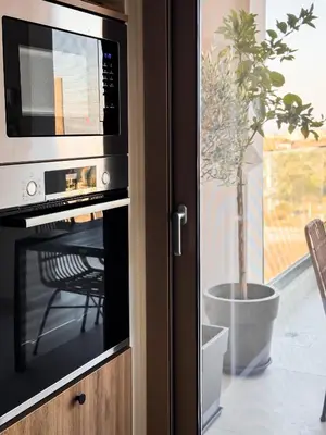 a microwave oven in a kitchen with a potted plant at Evilion Island Residence in Ixia