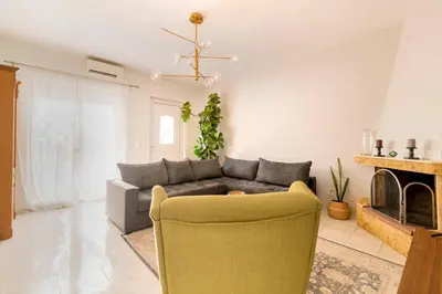 a living room with a couch and a fireplace at Central House of Ialisos in Ialyssos