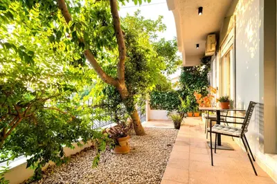 a patio with a table and chairs and trees at Central House of Ialisos in Ialyssos