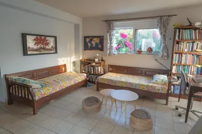 a bedroom with two beds and a table and a window at Private House, Peaceful Stylish Retreat Near Ialisos Beach, up to 5 Guests in Ialyssos