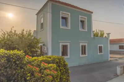 a blue house with a bush in front of it at Private House, Peaceful Stylish Retreat Near Ialisos Beach, up to 5 Guests in Ialyssos