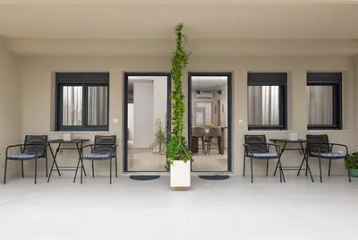 a room with tables and chairs and a plant at Ama Apartments in Rhodes Town