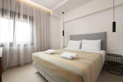 a bedroom with a large bed with two towels on it at Ama Apartments in Rhodes Town