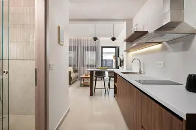a kitchen with white countertops and a dining room at Ama Apartments in Rhodes Town