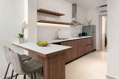 a kitchen with a island with a counter and chairs at Ama Apartments in Rhodes Town