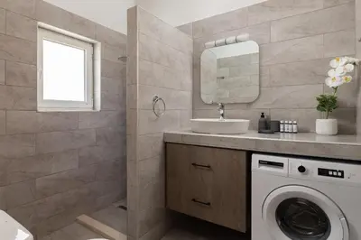 a bathroom with a washing machine and a sink at Avia Villa in Pefki Rhodes
