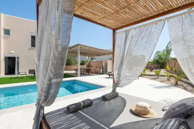 a patio with a bed and a swimming pool at Avia Villa in Pefki Rhodes