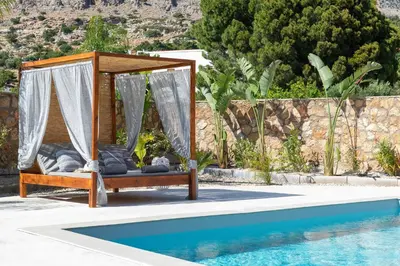 a canopy bed next to a swimming pool at Avia Villa in Pefki Rhodes
