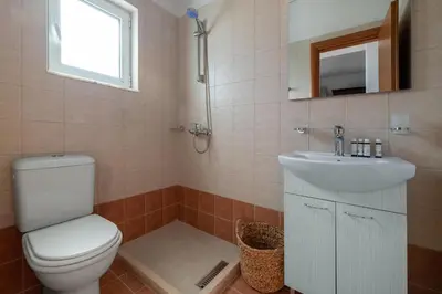 a bathroom with a toilet and a sink and a mirror at Avia Villa in Pefki Rhodes