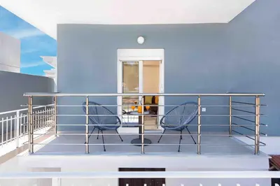 a balcony with two chairs and a blue wall at Modern Colorful House 1 rhodos in Rhodes Town