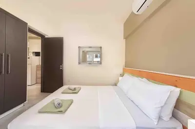 a bedroom with a large bed with two towels on it at Modern Colorful House 1 rhodos in Rhodes Town