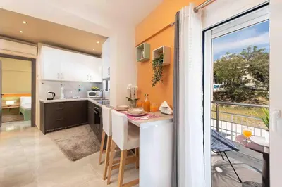 a kitchen with a table with chairs and a balcony at Modern Colorful House 1 rhodos in Rhodes Town