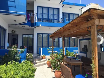 a patio with a wooden pergola in front of a building at Anastasia Studios, Apartments & Suites in Archangelos
