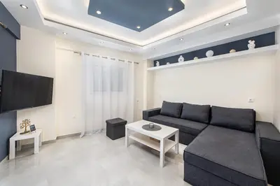 a living room with a black couch and a tv at Modern Colorful House 3 in Rhodes Town