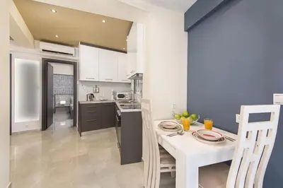 a kitchen with a table and a white table and chairs at Modern Colorful House 3 in Rhodes Town