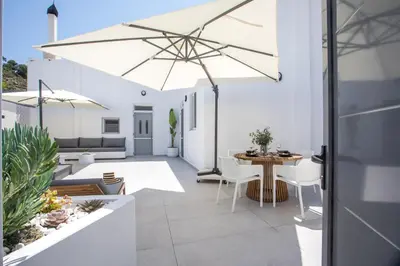 a patio with a table and a large umbrella at Chrispa Villa in Afantou