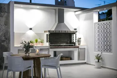 a kitchen with a table and chairs and a fireplace at Chrispa Villa in Afantou