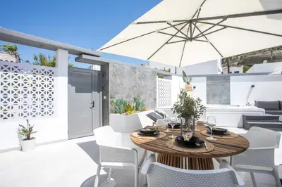 a patio with a wooden table and chairs and an umbrella at Chrispa Villa in Afantou