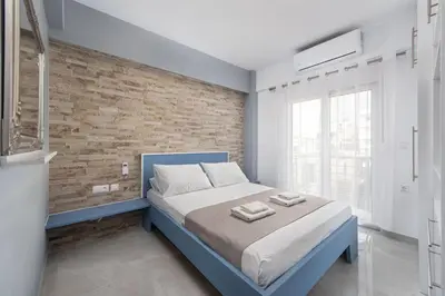 a bedroom with a blue bed and a brick wall at Modern Colorful House 4 Rhodos in Rhodes Town
