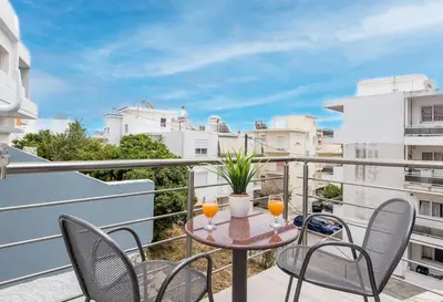 a balcony with chairs and a table with two glasses at Modern Colorful House 4 Rhodos in Rhodes Town