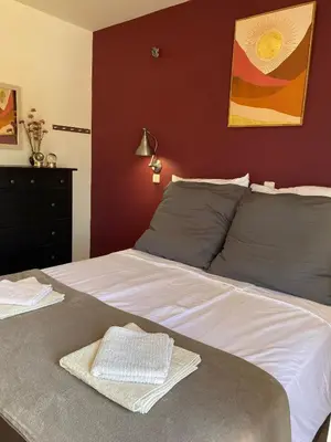 a bedroom with a large white bed with a red wall at Villa Eos in Kalavárda