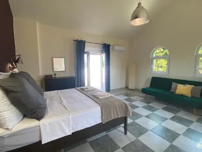 a bedroom with a bed and a green couch at Villa Eos in Kalavárda