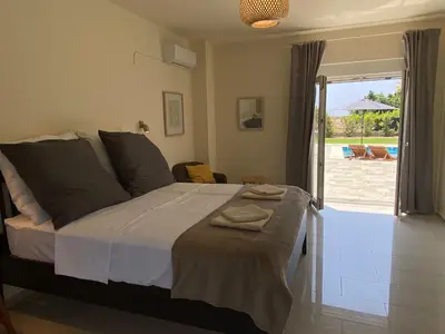 a bedroom with a bed with a view of a patio at Villa Eos in Kalavárda