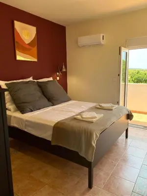 a bedroom with a bed and a door to a balcony at Villa Eos in Kalavárda