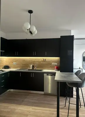 a kitchen with black cabinets and a table at Casa Aurelia Archangelos in Archangelos