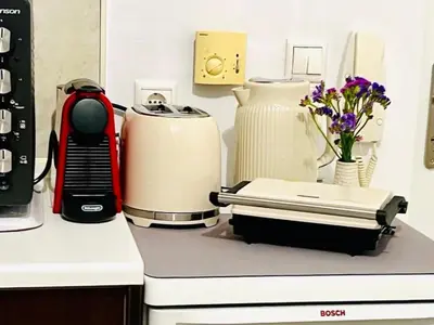 a counter top with a coffee maker and vase of flowers at Andreana's House Rhodes in Rhodes Town