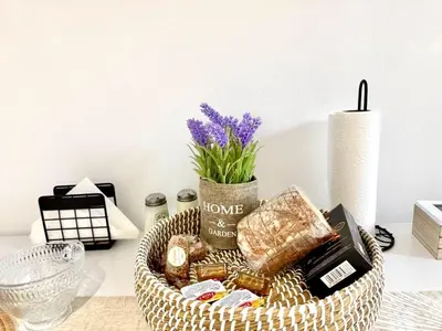 a basket of food and a vase with purple flowers at Andreana's House Rhodes in Rhodes Town