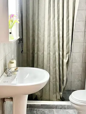 a bathroom with a sink and a shower curtain at Andreana's House Rhodes in Rhodes Town