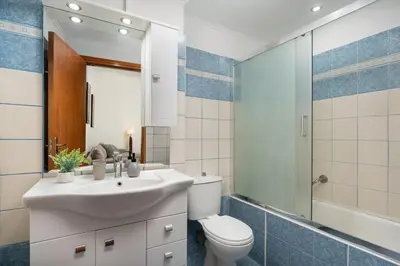 a bathroom with a sink and a toilet and a mirror at Minimal & Bright Apartment in Ialyssos