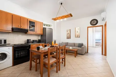 a kitchen and living room with a table and chairs at Minimal & Bright Apartment in Ialyssos