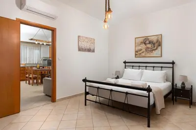 a bedroom with a bed and a dining room at Minimal & Bright Apartment in Ialyssos