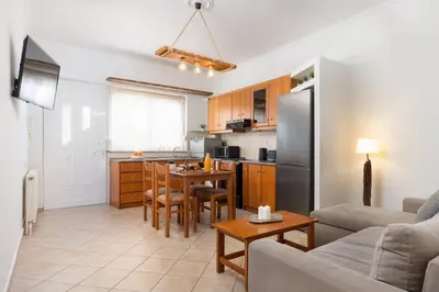 a kitchen and living room with a table and a couch at Minimal & Bright Apartment in Ialyssos
