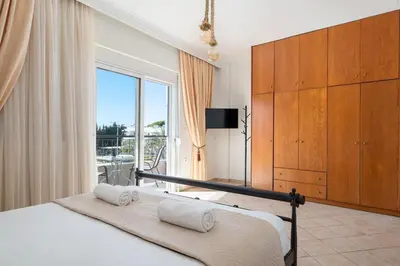 a bedroom with a bed and a large window at Minimal & Bright Apartment in Ialyssos