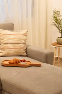 a tray with a plate of food on a couch at KMS Summer House Ialisos in Rhodes Town